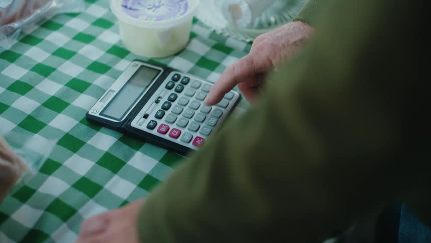 A man is pressing buttons on his calculator