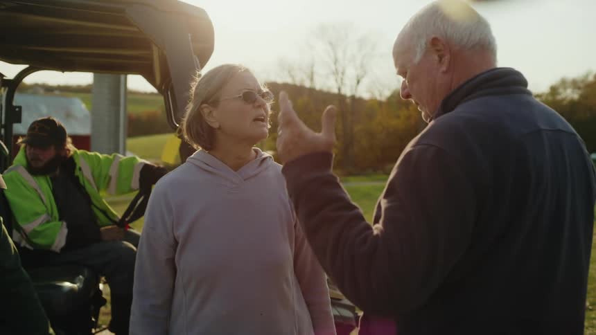 A man and woman talk on the farm