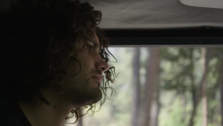 A man rides in a vehicle in the woods