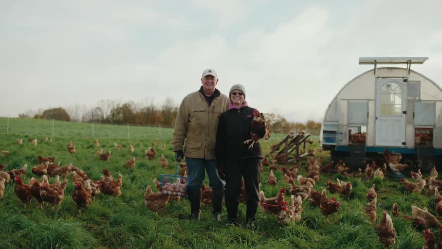 Farmers pose with their chickens on the farm