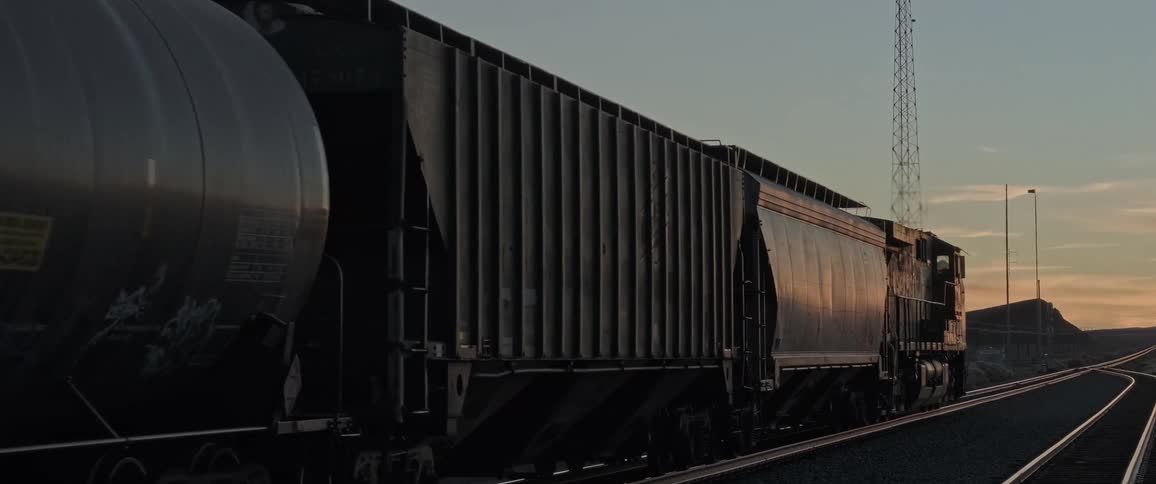Freight train with tank cars and closed cars moving on rails