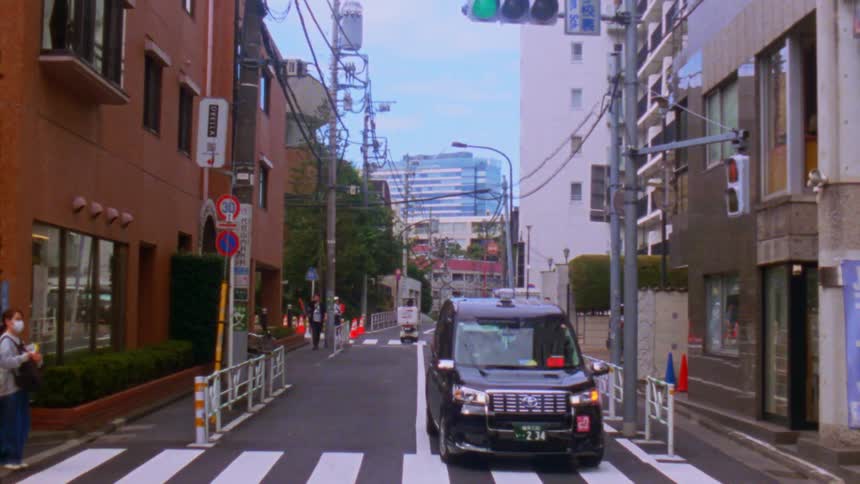 People make their way through a city on a mostly empty street