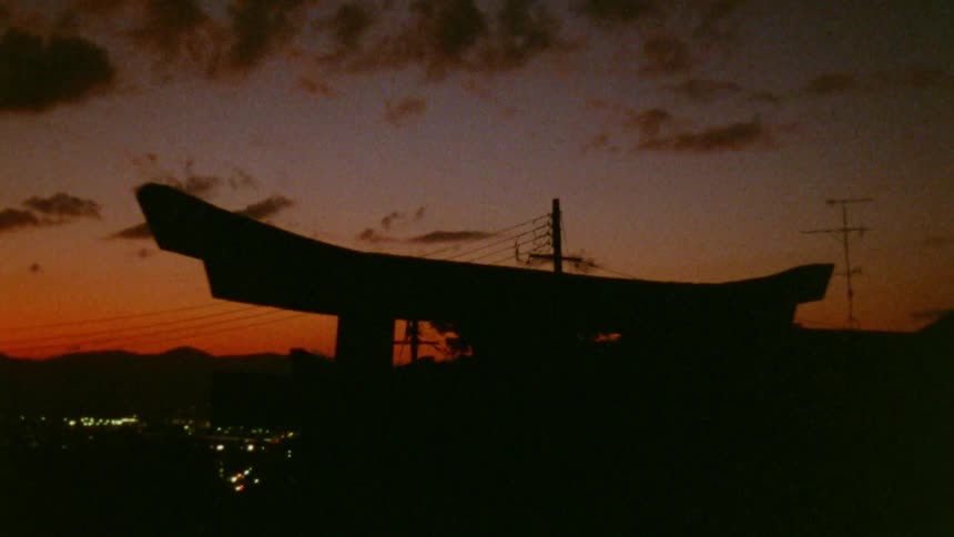 A wooden arch is seen overlooking a city