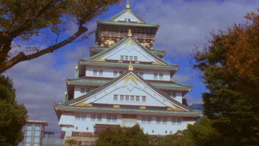 The osaka castle in japan under a partly cloudy sky