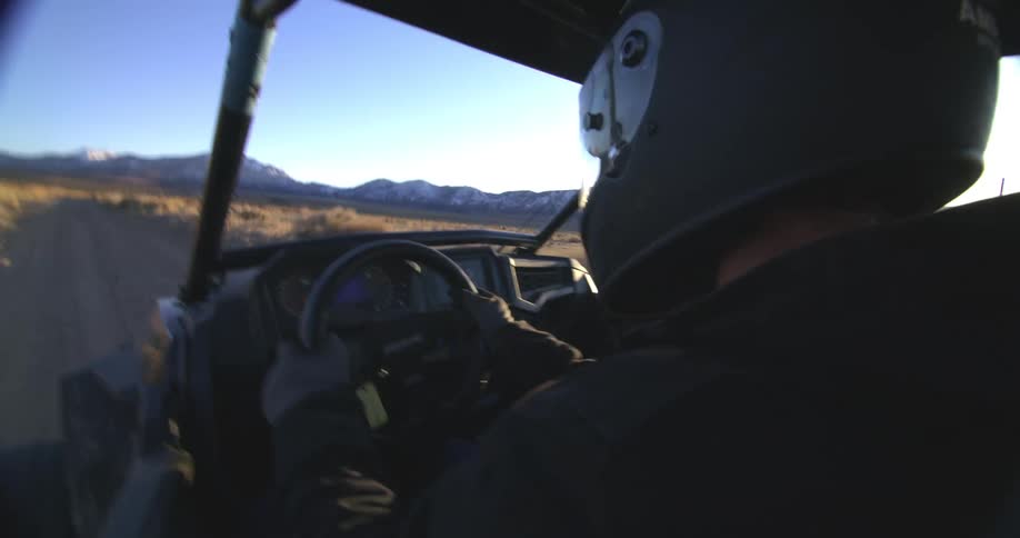 A man is jostled around as he rides in a dune buggy across the desert