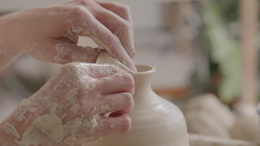 A person is sculpting a jar