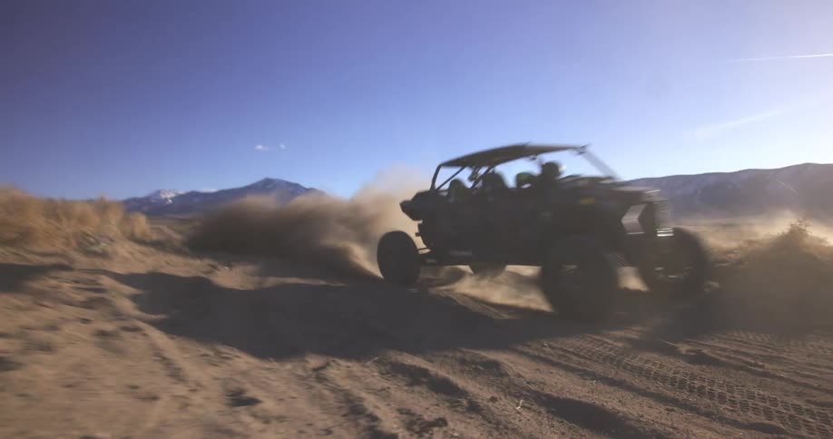 The off road vehicle does a wide turn in the sand