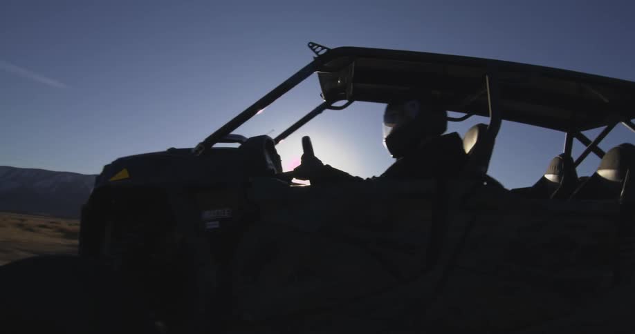 A person is driving an off road vehicle in the badlands