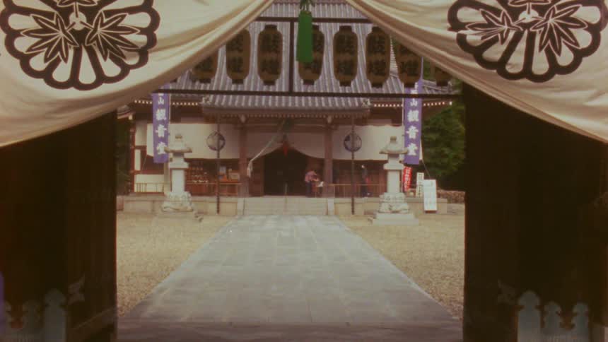 Two people arriving at the entrance to the courtyard around a building bow
