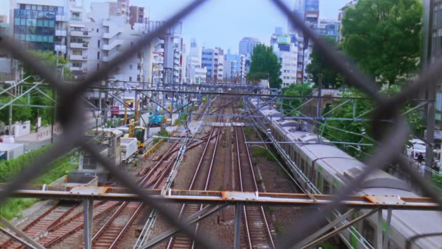 A passenger train moves through the center of a city