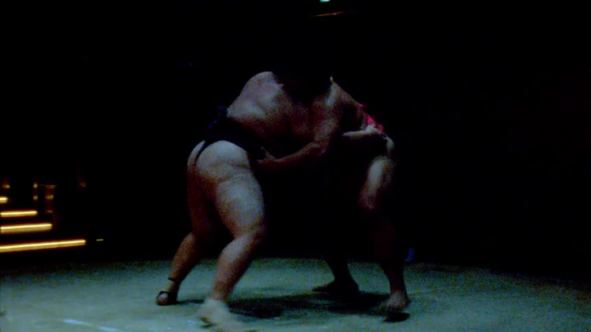 Two sumo wrestlers push and strike each other