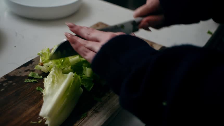 Woman next to a man cutting vegetables in the sink