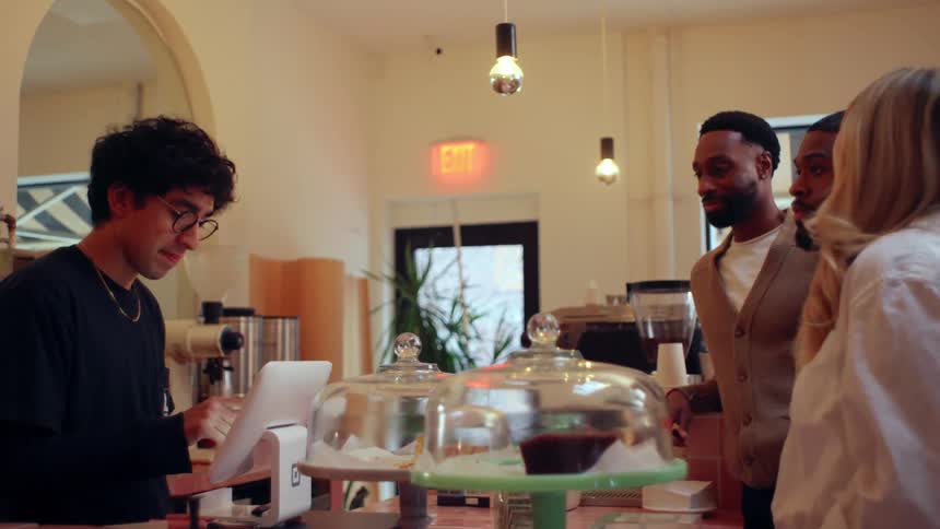 Shop counter clerk takes orders from smiling customers