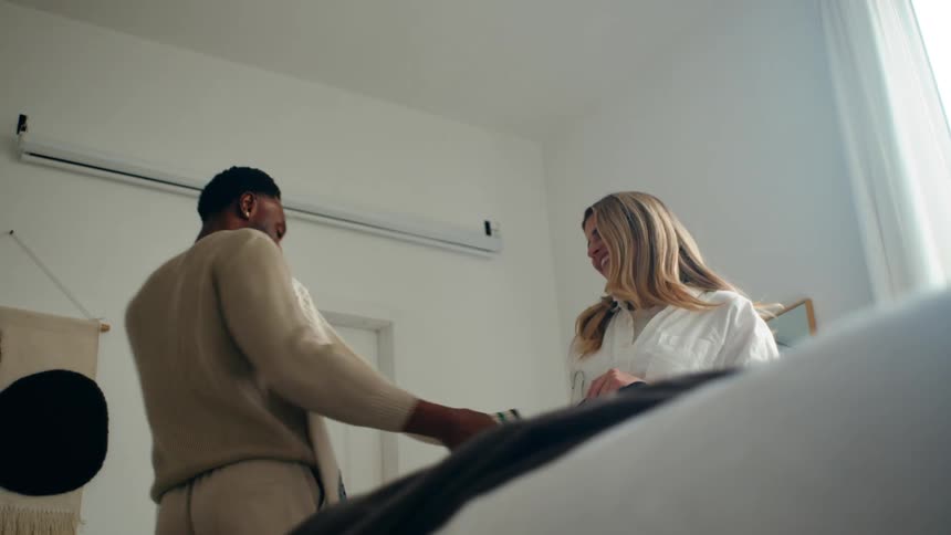 A young couple tries on clothes in a well lit room