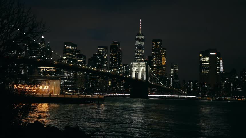 The city and bridge are brightly lit at night