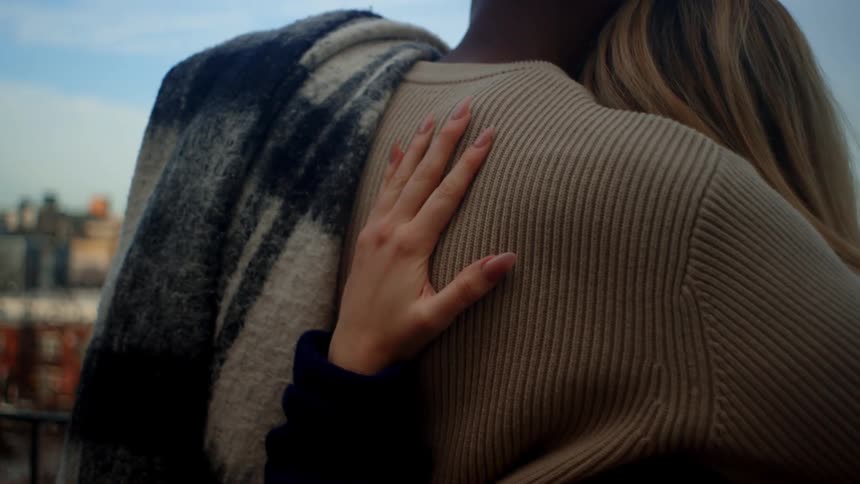 Couple hugging seen from behind in an outdoor setting