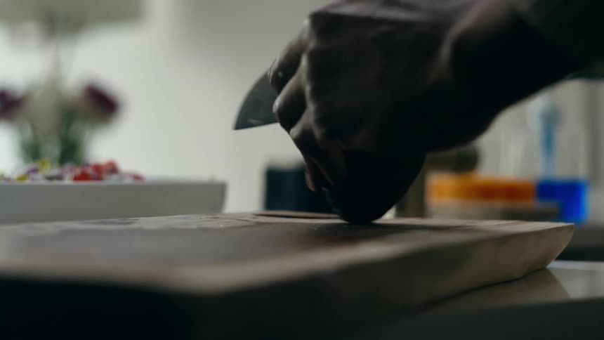 A man cuts an avocado on the chopping board
