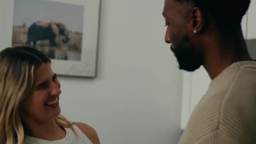 Woman putting food in a mans mouth and the two hug happily