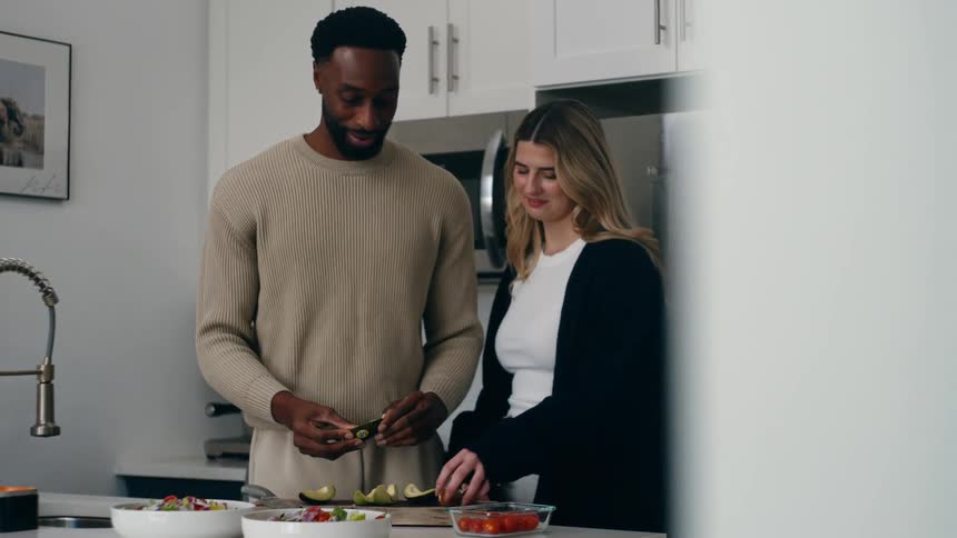 A man and women are preparing food in the kitchen