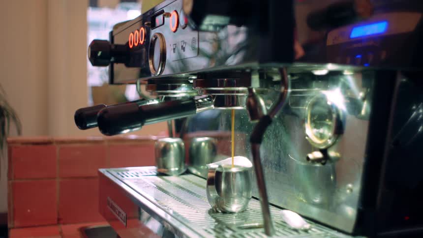 Coffee machine pouring into a metal mug