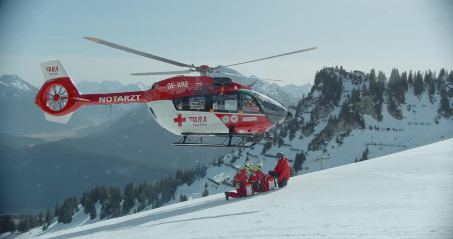 A medical helicopter hovers over a teach of rescuers and a victim