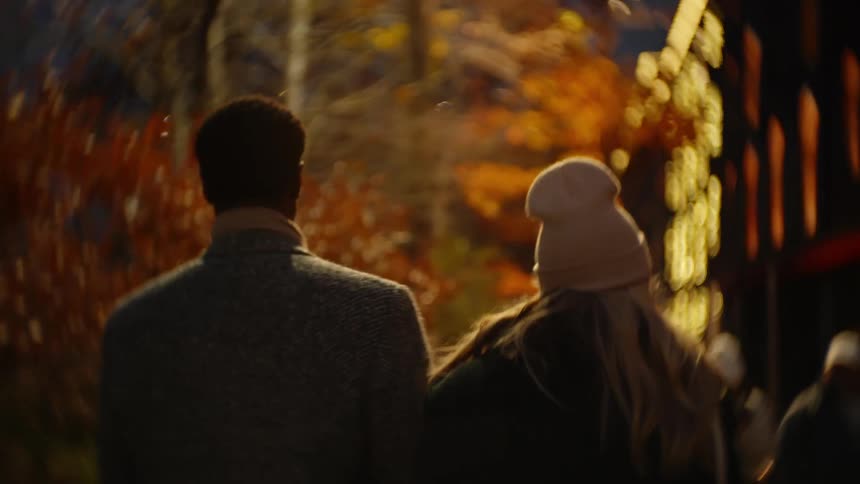 A man and woman walk close together in the city