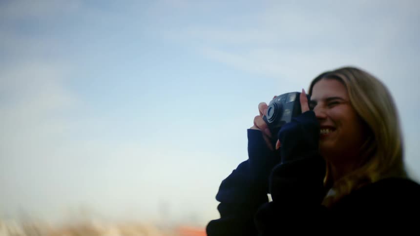 A woman takes a photo of a man with her camera