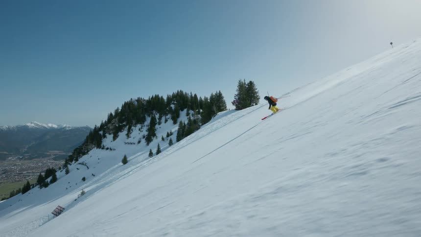 A man is skiing down a steep slope