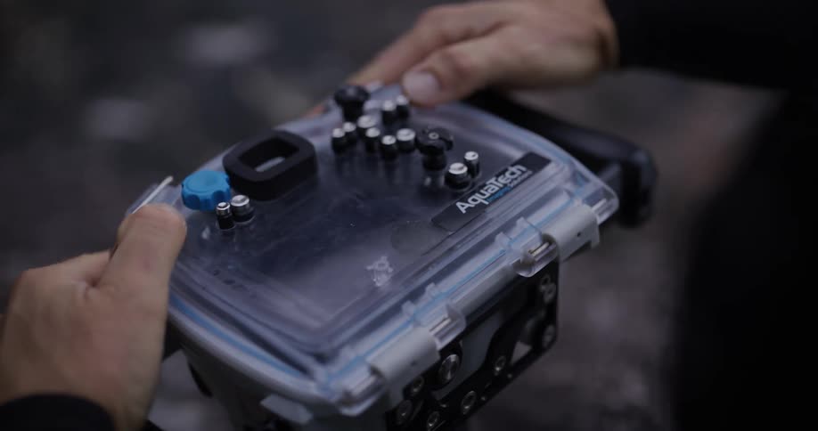 Pair of hands closing a protective cover on a professional camera