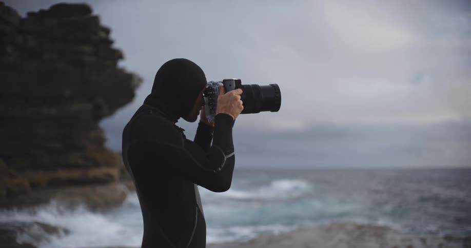 A man takes a photograph of the ocean