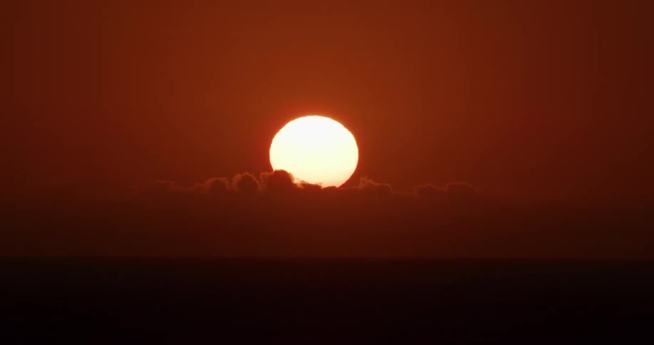 Landscape of a reddish sky with the sun in the background