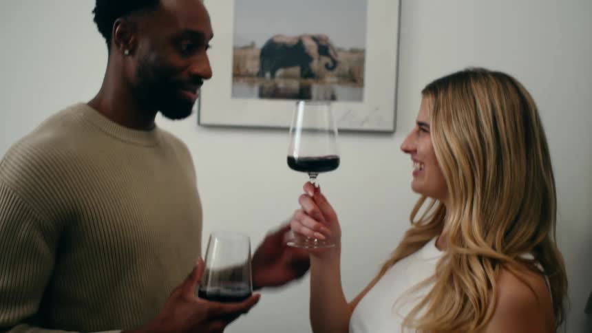 Happy couple toasting with glasses of red wine