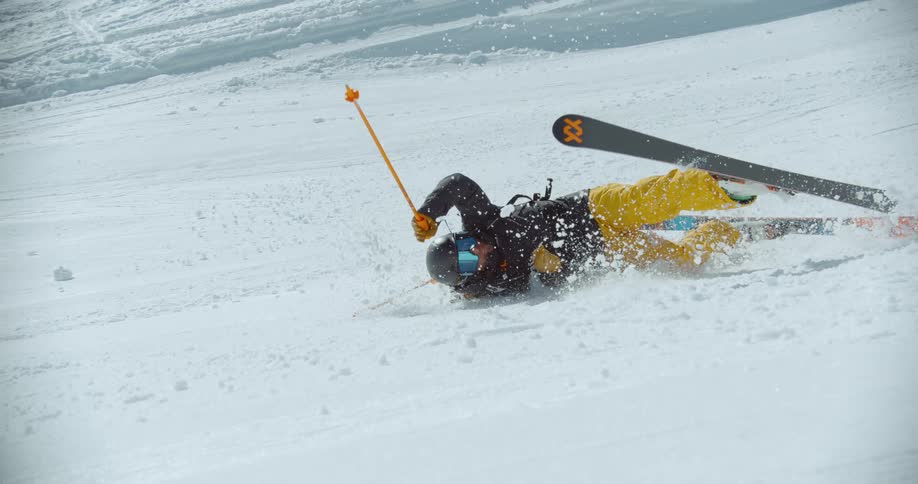 Man falling to the ground while skiing outdoors during day time