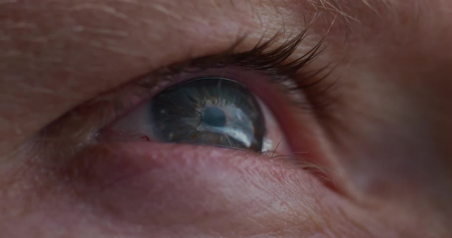 Close up of a persons eye reflecting the sky