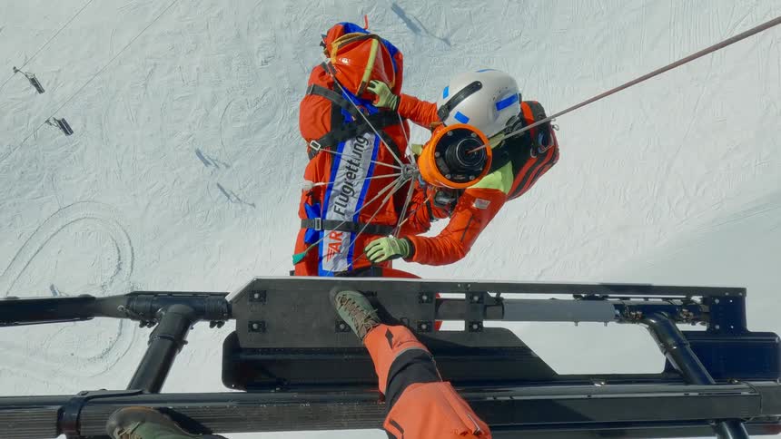 Rescue workers are lifting a person into a helicopter