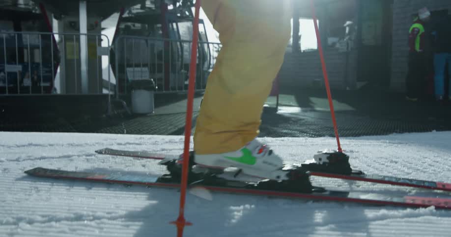 Man wearing ski gear with other people and a gondola lift on the background outdoors during day time