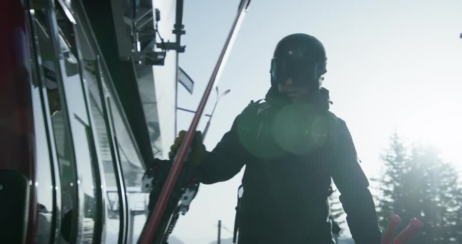 Skiers exit a gondola on a ski lift and take their skis on a winter day