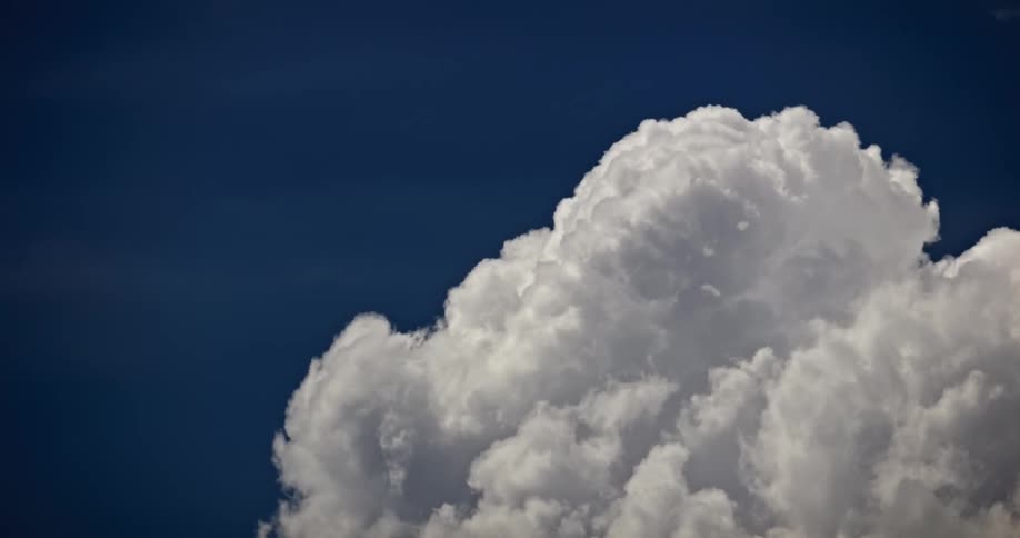 Large white cloud bank contrasts with a deep blue sky