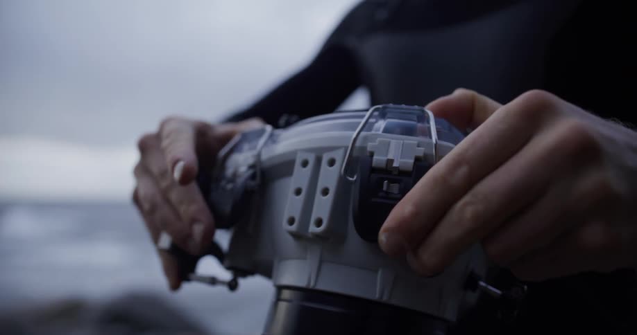 A man aims his camera on the shore
