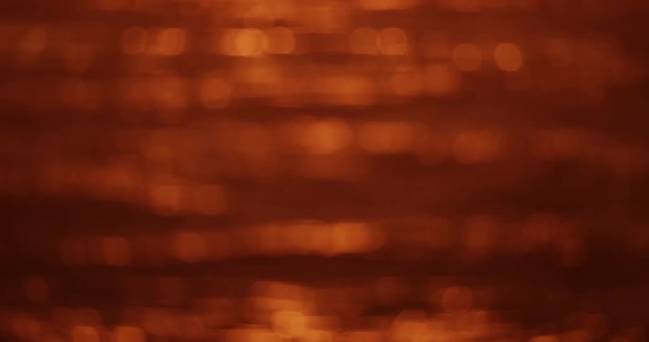 Shimmering water with a warm orange hue creating a bokeh effect