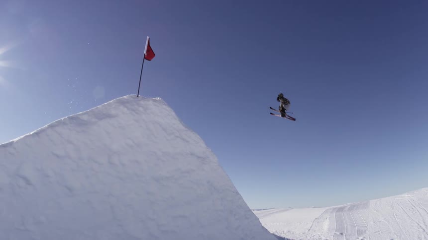 Person doing a high jump on a slope on a sunny day