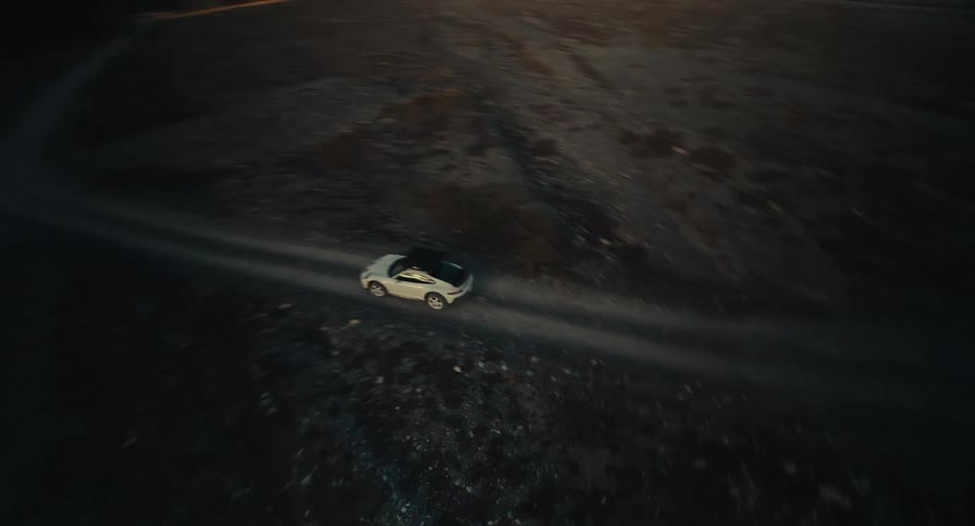 A small car races on the trail on the landscape