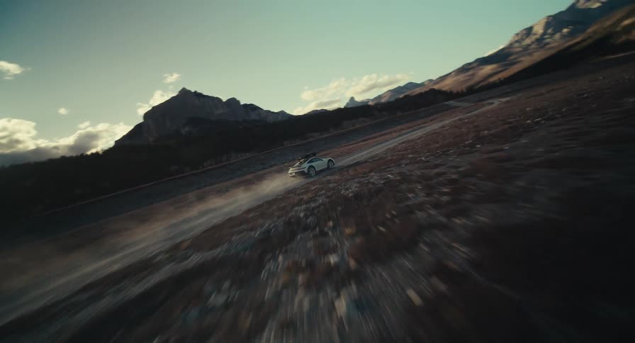 Car travelling on a road in the middle of the desert surrounded by mountains during day time