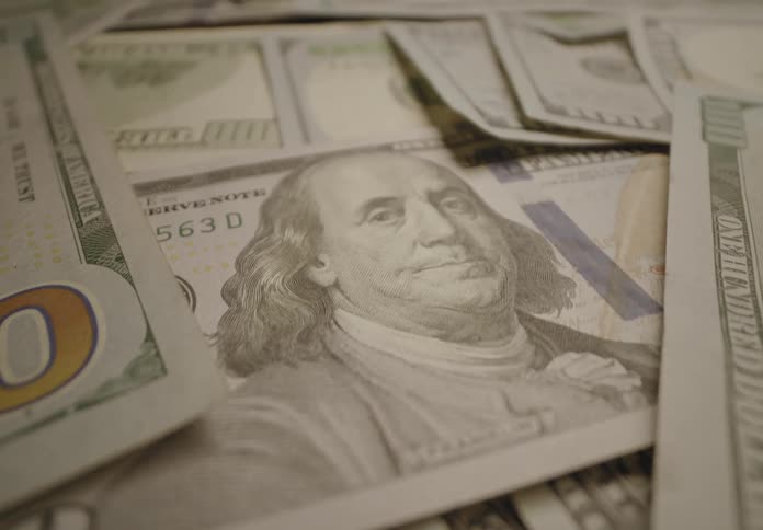 Cash is erratically stacked on a table indoors