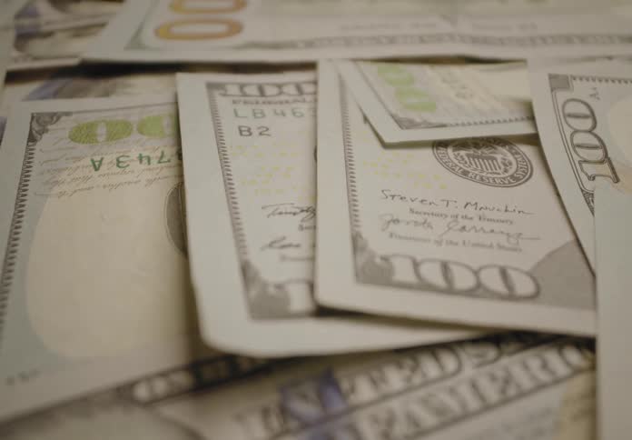 A clip of hundred dollar bills in cash