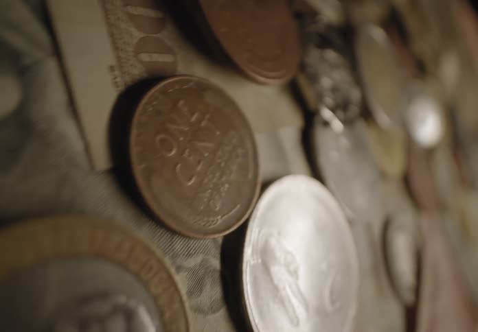 Piles of coins from different countries are on a table
