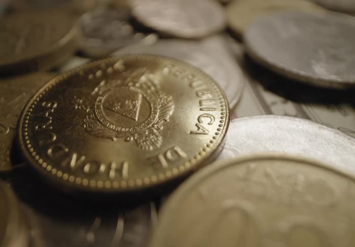 A pile of coins and money are on the table