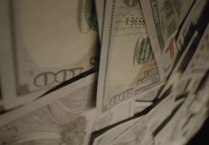 Thousands of dollars are stacked on a table