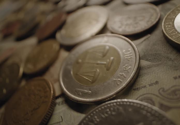 Money bills and coins over a surface indoors