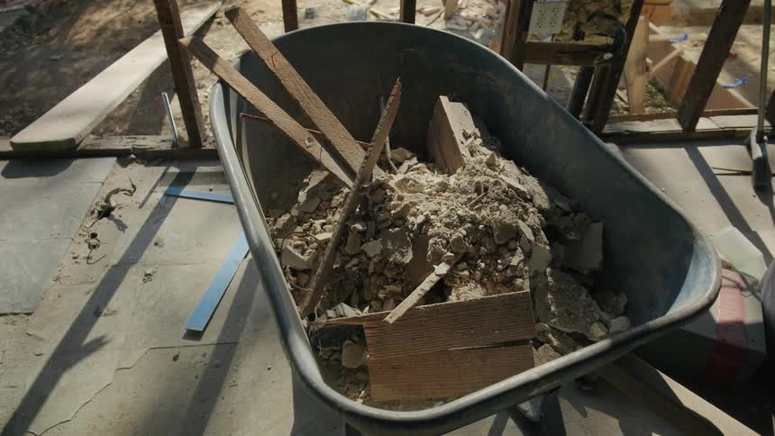A wheelbarrow on the work site is filled with debris